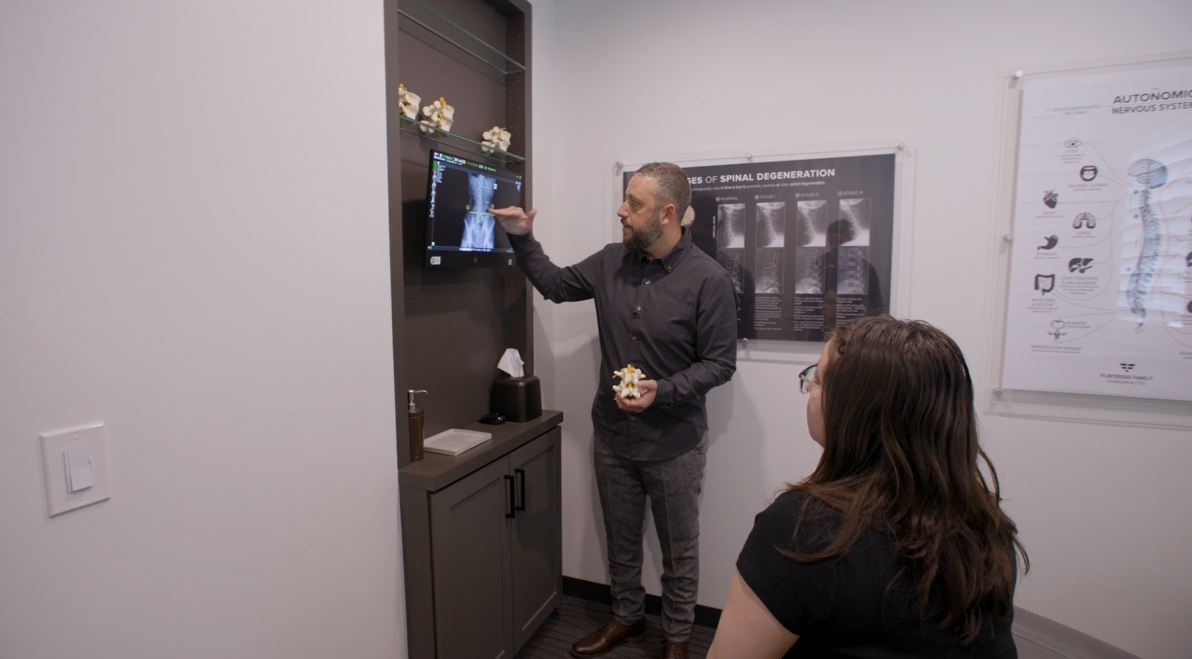 Doctor reviewing digital X-ray with patient in exam room